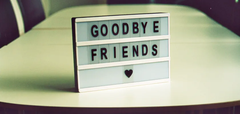 Schild Goodbye Friends auf Konferenztisch